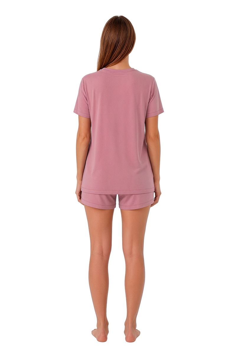 Woman wearing a pink pajama set on a white background