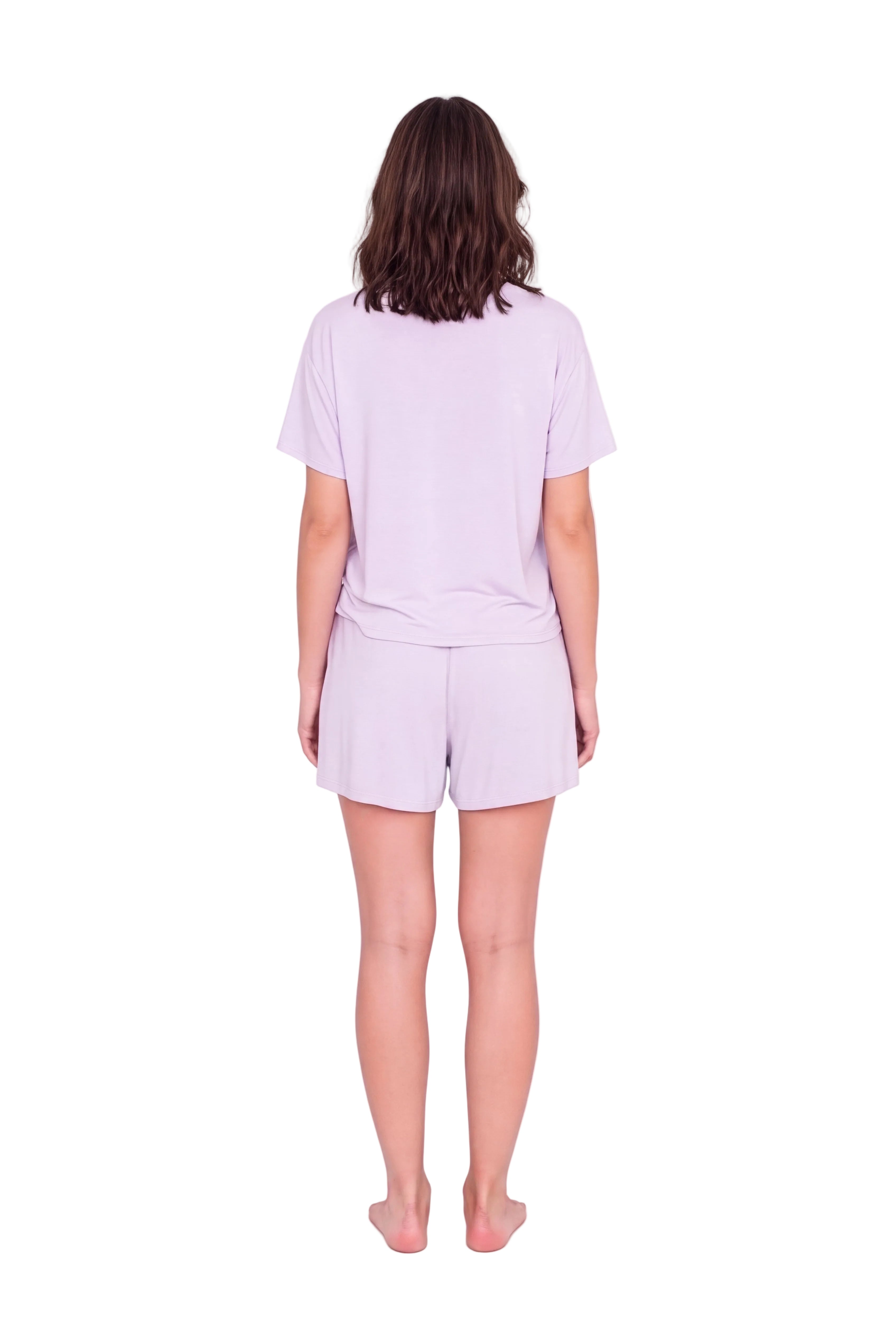 A woman viewed from behind wearing a light lavender short-sleeve t-shirt and matching light lavender shorts against a plain white studio background.