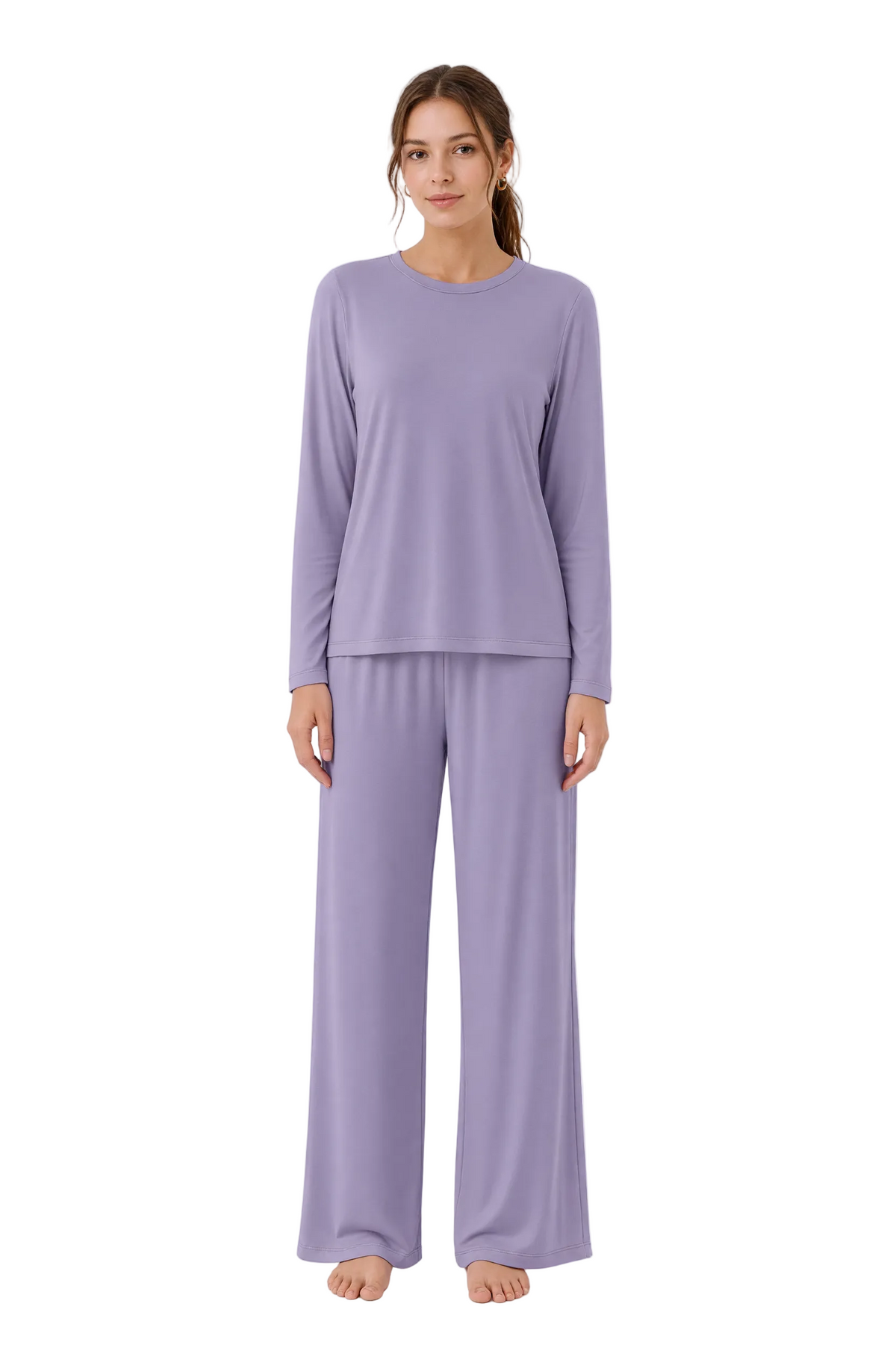 A woman modeling a matching two-piece pajama set in a soft lavender-purple color, featuring a long-sleeve crewneck top and wide-leg pants, photographed against a seamless white studio background.