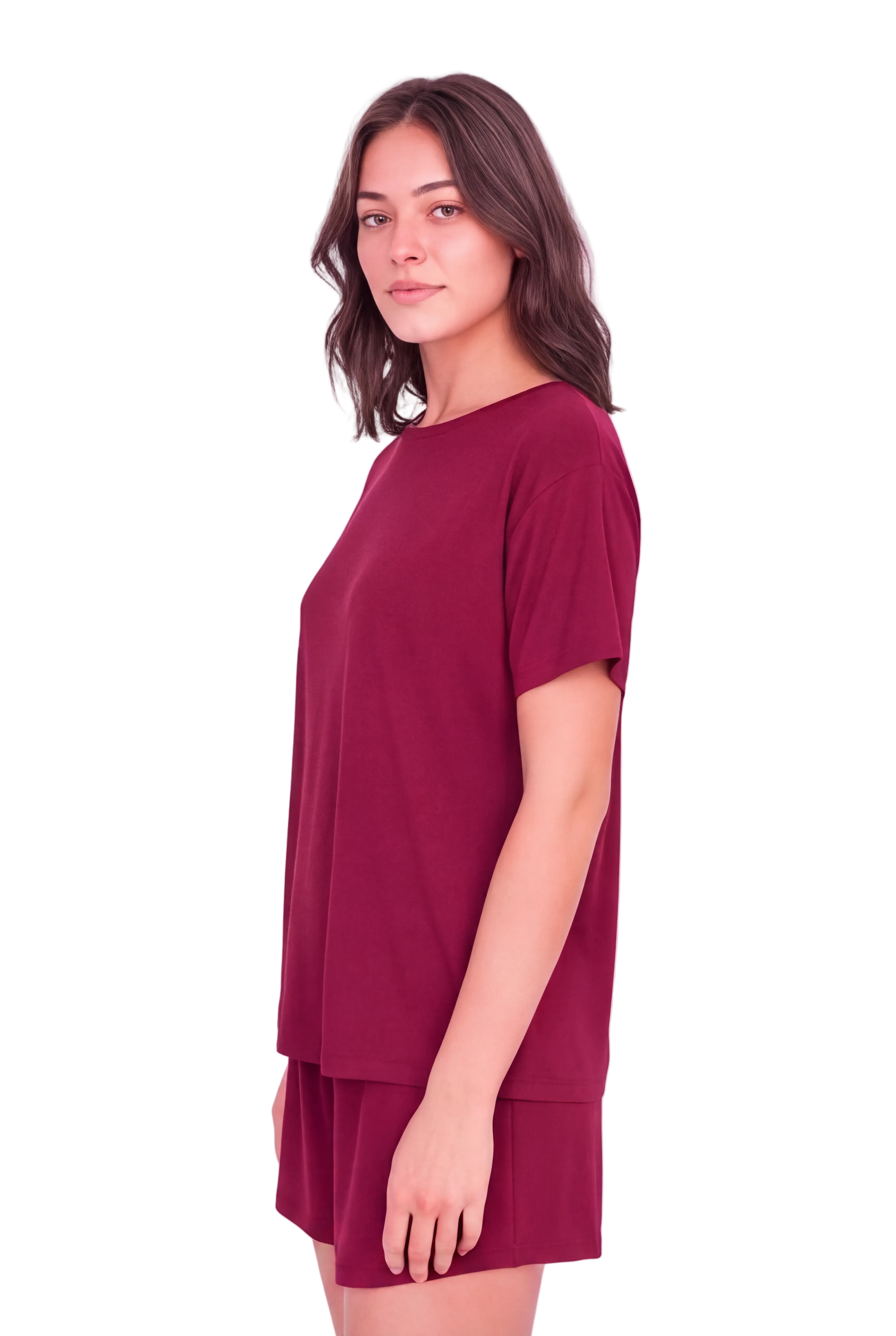 A woman modeling a short-sleeve crewneck t-shirt dress in deep burgundy, paired with matching shorts, against a solid pale pink background.